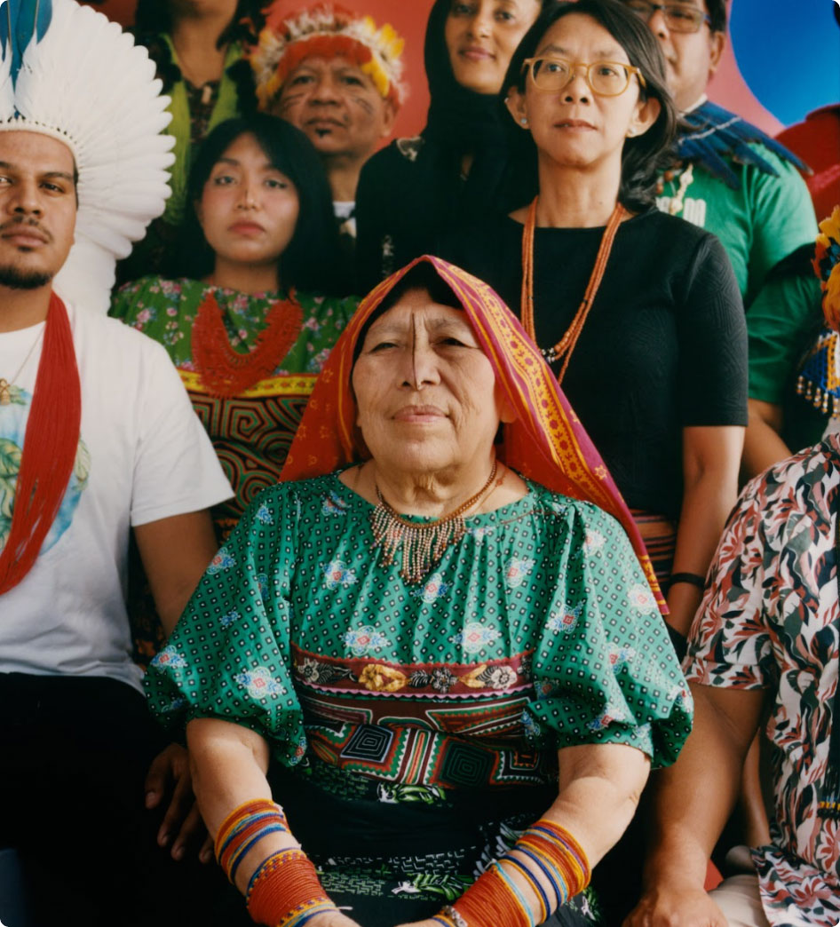 "Indigenous and local community leaders from member organizations of
the Global Alliance of Territorial Communities in a group photo against an orange
background."